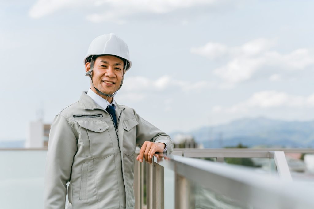 作業着でヘルメットをかぶる男性の画像